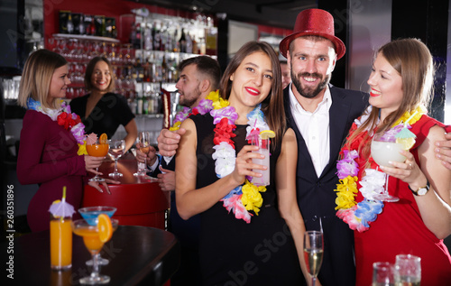 Man and two women on Hawaiian party at nightclub