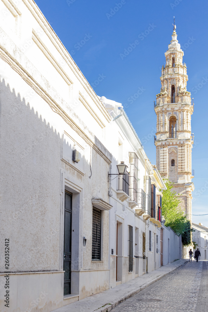 Beautiful Street in Estepa (province of Seville) with Tower of Victory in the background. Charming white village in Andalusia. Southern Spain. Picturesque travel destination on Spain.