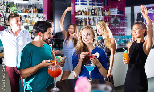 Man with woman are drinking cocktails on corporate party.