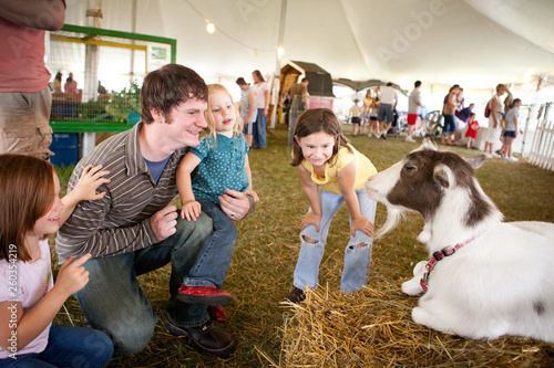 Family Looking at a Goat at Agricultural Fair photo
