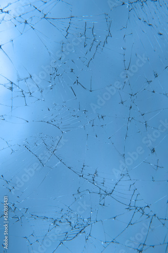 glass in the cracks on a blue background. texture. broken window, phone screen