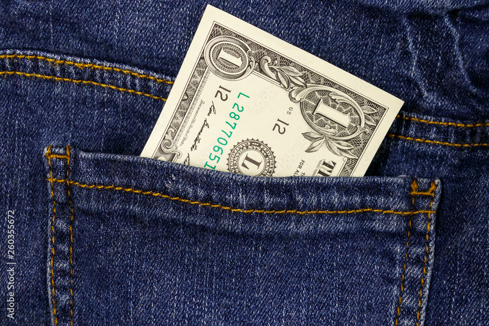 One dollar bill in a pocket of blue jeans One dollar bill in a pocket of blue jeans