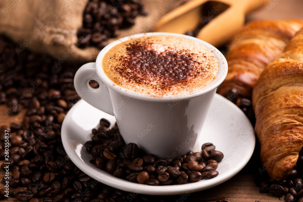 Cup of coffee surrounded by coffee beans Cup of coffee surrounded by coffee beans
