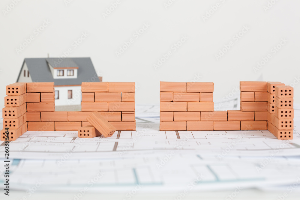Fototapeta premium Model house construction with brick on blueprint