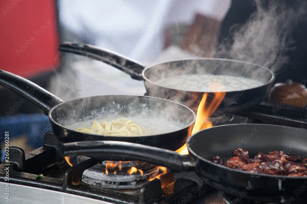 Frying pan on fire, chef Frying vegetables on fire throwing them in a frying pan. Frying pan on fire, chef Frying vegetables on fire throwing them in a frying pan.