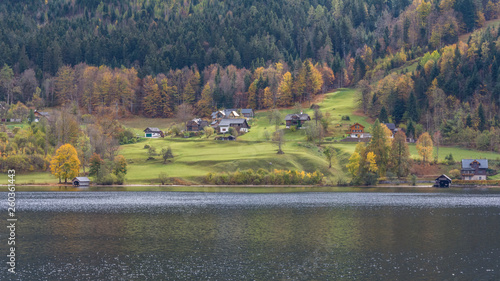 Landscape with illuminated houses by sun rays on the coastline of mountain lake. photo