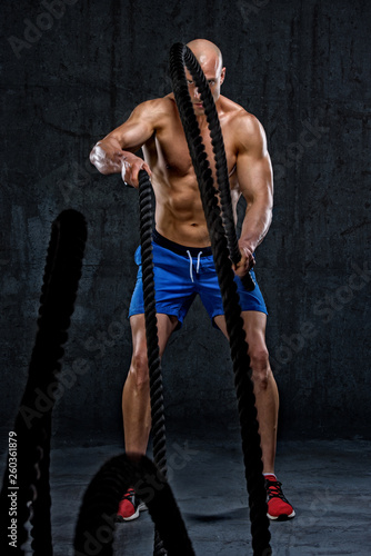 Musuclar Men Battling Ropes as Part of Cross Training photo