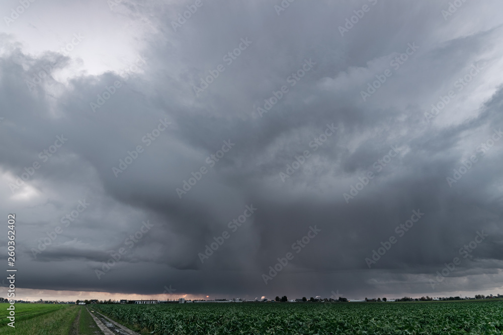 Scary looking storm over the wide open dutch landscape with rain streaks and funnel cloud Scary looking storm over the wide open dutch landscape with rain streaks and funnel cloud