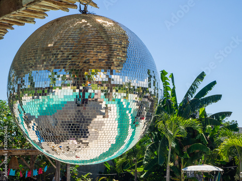 Disco ball reflecting green swimming pool. Bali.