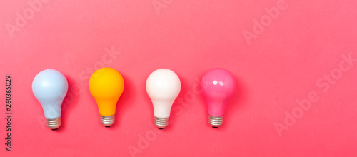 Colored light bulbs on a pink paper background