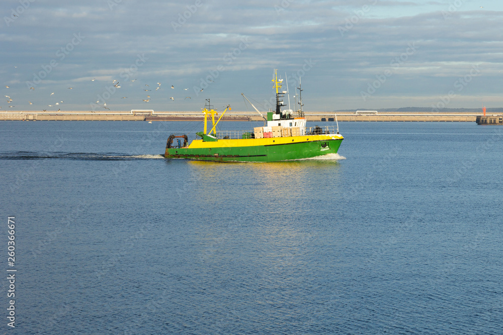 Fototapeta premium a small fishing boat returns to port