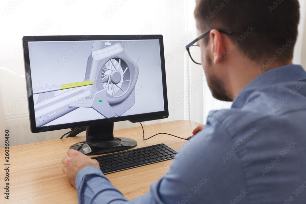 Engineer, Constructor, Designer in Glasses Working on a Personal Computer. He is Creating, Designing a New 3D Model of Helicopter in CAD Program. Freelance Work Engineer, Constructor, Designer in Glasses Working on a Personal Computer. He is Creating, Designing a New 3D Model of Helicopter in CAD Program. Freelance Work