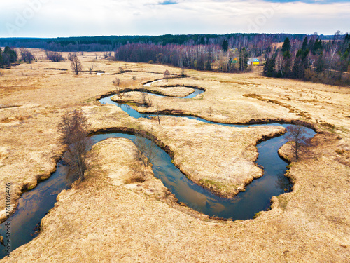 Aerial view of brook bends in spring medow. Belarus