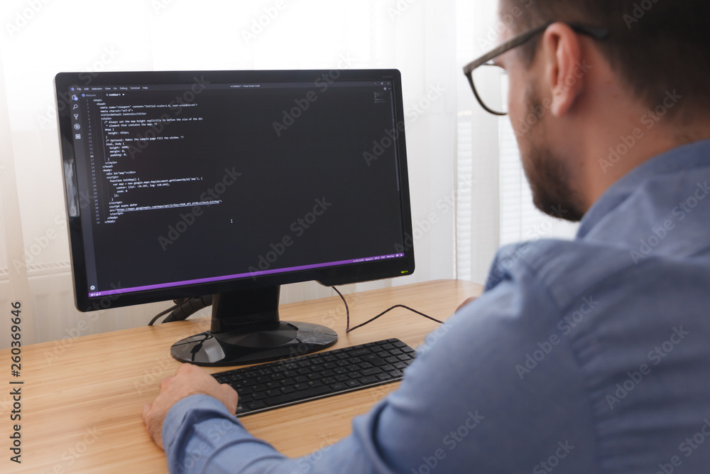 Programmer in Glsses Typing New Lines of HTML Code. Web Design Business and Web Development Concept. Freelance Work Programmer in Glsses Typing New Lines of HTML Code. Web Design Business and Web Development Concept. Freelance Work