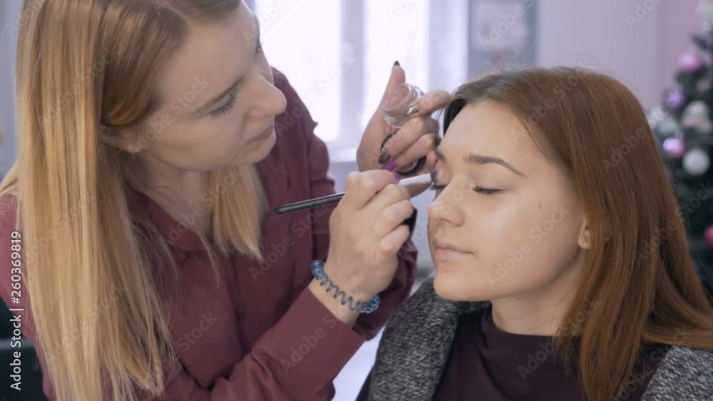 professional make-up artist the girl makes the shading of the shadows on the eyelid of the client 4K professional make-up artist the girl makes the shading of the shadows on the eyelid of the client 4K