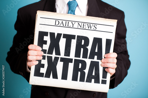 Businessman Holding Newspaper with EXTRA! EXTRA! Headline - News Announcement photo