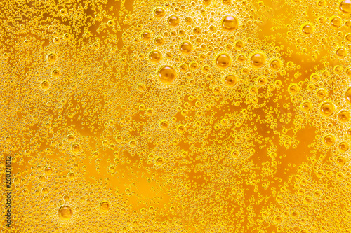 Close up of beer bubbles and foam as a background. Droplets on freshly poured beer texture.