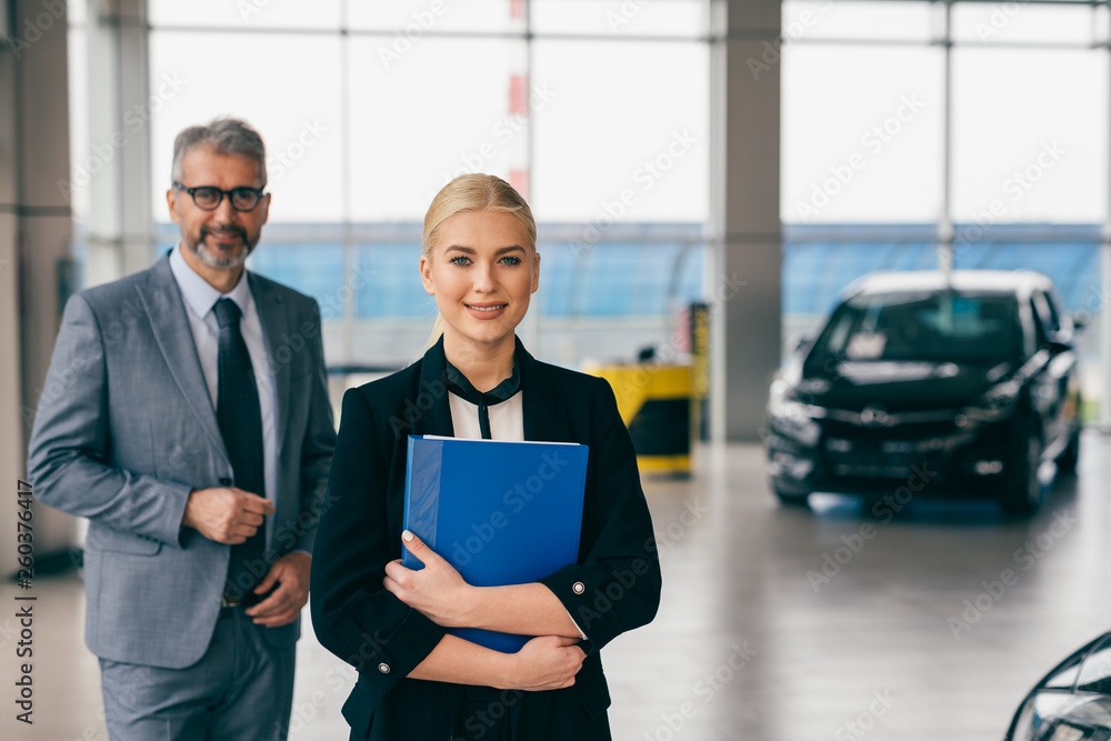 saleswoman and sales man in car dealership showroom saleswoman and sales man in car dealership showroom