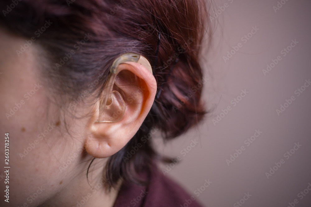 Close-up photo of a woman with hearing aid behind her ear. Sensory disability. Hearing disability Close-up photo of a woman with hearing aid behind her ear. Sensory disability. Hearing disability
