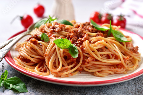 Traditional italian spaghetti bolognese with meat sauce, basil and parmesan cheese.