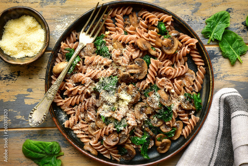 Whole wheat fusilli pasta with mushroom and spinach.Top view with copy space.