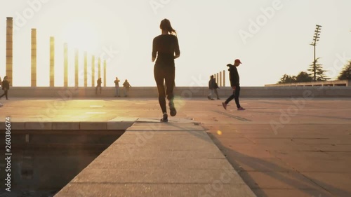 Young girl is preparing to run in park in summer, heathy lifestyle, sport conception. Woman runs on the road in good weather. Woman is engaged in sports in the fresh air.
