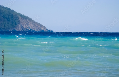  Waves of the sea against the backdrop of mountains. Turkey, the Mediterranean Sea, the village of Cirali.