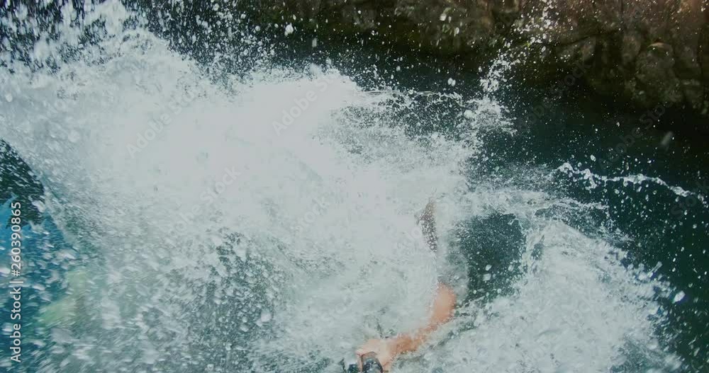 POV shot of young couple cliff jumping together in the jungle POV shot of young couple cliff jumping together in the jungle