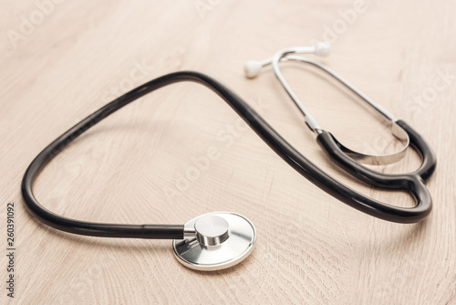 selective focus of stethoscope on wooden and white table