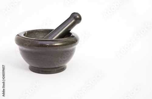Black marble pestle and mortar on white background on left.
