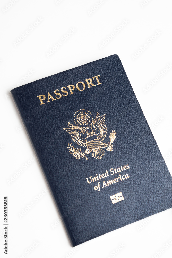 The iconic blue cover of an American passport deliberately and artistically set on a plain white background. The iconic blue cover of an American passport deliberately and artistically set on a plain white background.