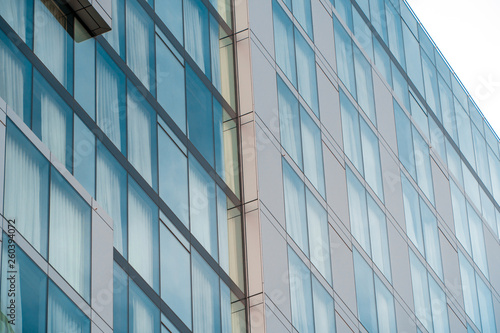 Real estate lease concept. Blue windows of office building close up