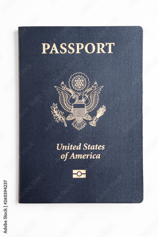 The iconic blue cover of an American passport deliberately and artistically set on a plain white background. The iconic blue cover of an American passport deliberately and artistically set on a plain white background.