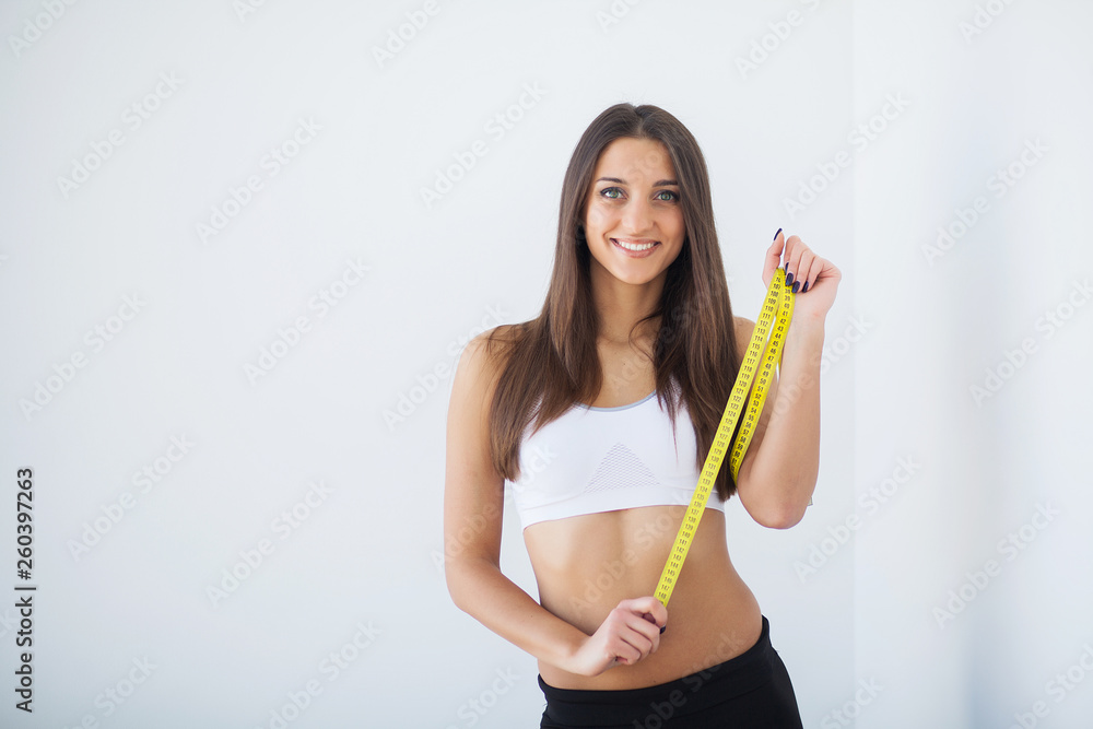 Diet. Portrait of beautiful young woman measuring her figure size with tape measure Diet. Portrait of beautiful young woman measuring her figure size with tape measure
