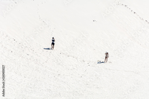 A man and a woman on the dunes area in Joaquina Beach, Florianopolis, Brazil.
