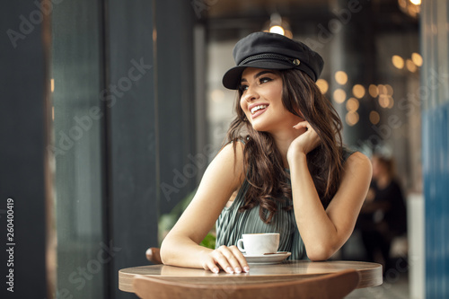 Positive girl drinking coffee at cafeteria.