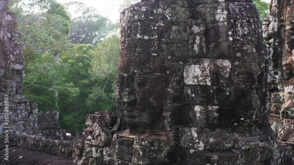 Sliding view of massive giant face-towers depicting Bodhisattva Avalokiteshvara at Bayon Temple, a richly decorated Khmer temple at Angkor in Cambodia built in the late 12th century Sliding view of massive giant face-towers depicting Bodhisattva Avalokiteshvara at Bayon Temple, a richly decorated Khmer temple at Angkor in Cambodia built in the late 12th century