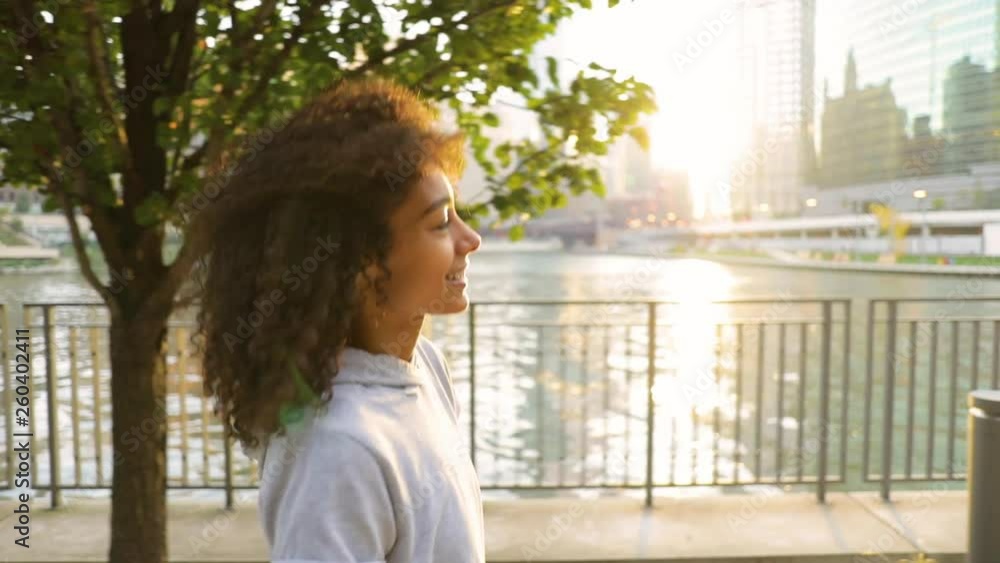Cute African American woman walking along the Chicago River after her morning workout. Cute African American woman walking along the Chicago River after her morning workout.