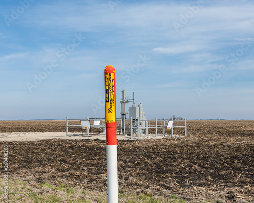 natural gas pipeline in farm field with emphasis on warning sign in foreground