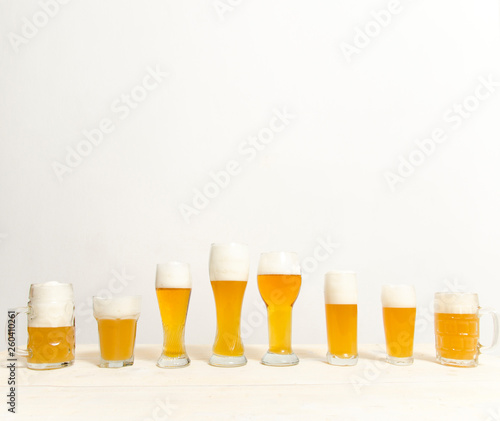 Copy space, eight glasses filled with beer , different shapes and sizes 