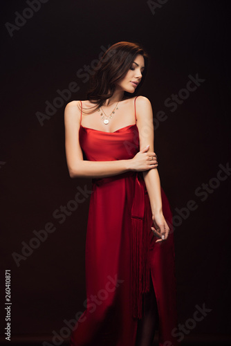 beautiful sensual woman in red dress posing isolated on black