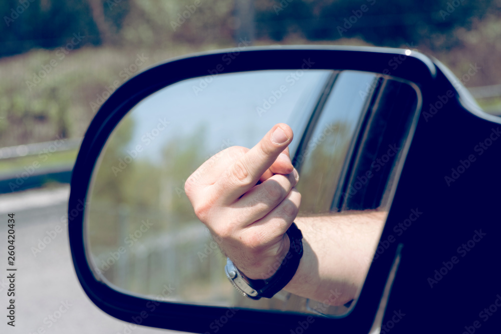 Ein Mann zeigt den Mittelfinger aus dem Auto Fenster Stock Photo