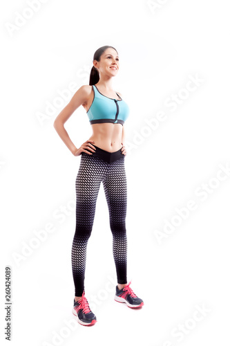 Sporty woman smilling and posing on white isolated background. Photo of muscular woman in sportswear on white background. Strength and motivation.