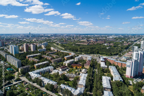 Top down aerial drone image of a Ekaterinburg city and plant in the midst of summer, backyard turf grass and trees lush green.
