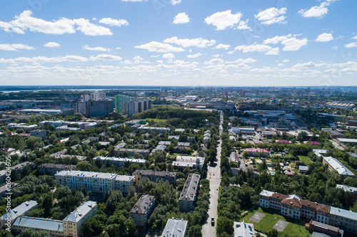 Top down aerial drone image of a Ekaterinburg with low houses and new high-rise buildings. Midst of summer, backyard turf grass and trees lush green. © flyural66