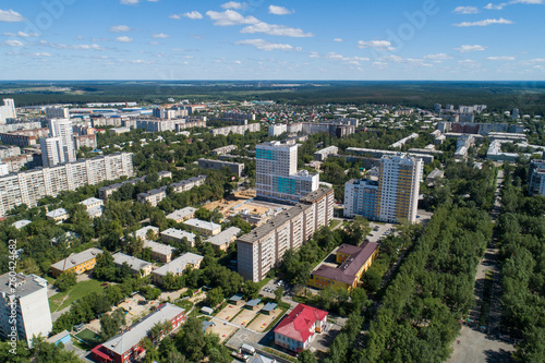 Top down aerial drone image of a Ekaterinburg with low houses and new high-rise buildings. Midst of summer, backyard turf grass and trees lush green. © flyural66