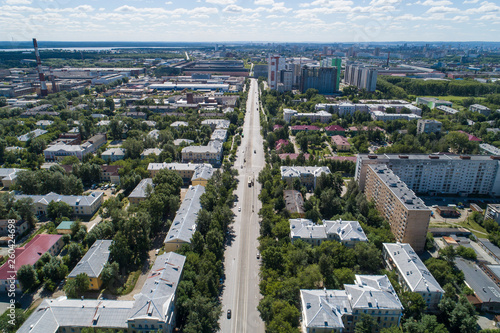 Top down aerial drone image of a Ekaterinburg with low houses and new high-rise buildings. Midst of summer, backyard turf grass and trees lush green.