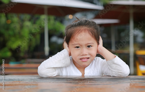 Smiling little Asian child girl lying on the wooden table with looking camera.