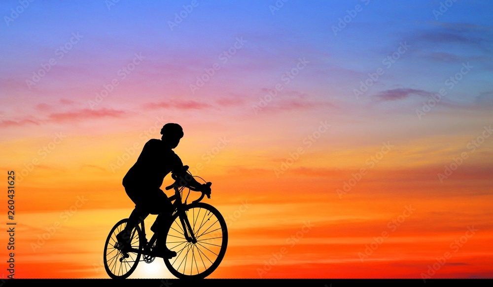 Obraz premium Silhouette man and bike relaxing on blurry sky background.