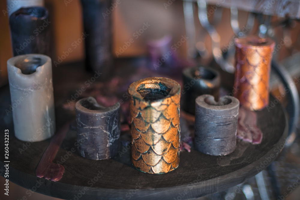 Many old beautiful candlesticks are on the table in the room